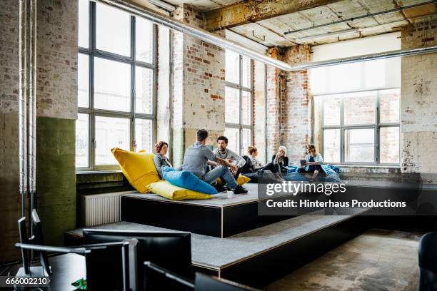 young casual business people during an informal meeting - men and women in a large group listening stock pictures, royalty-free photos & images