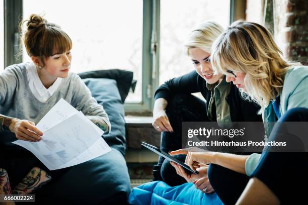 businesswomen talking during an informal meeting - millennial stock-fotos und bilder