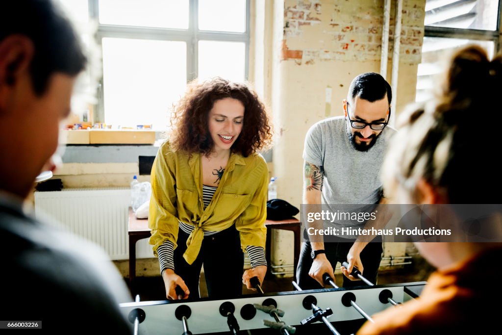 Start up business colleagues playing table soccer
