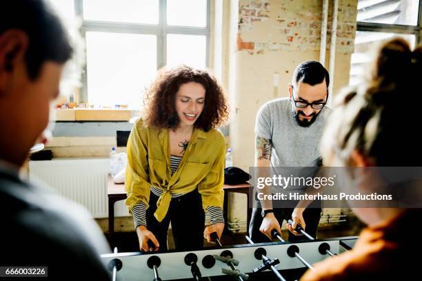 start up business colleagues playing table soccer - playing toy men stock pictures, royalty-free photos & images