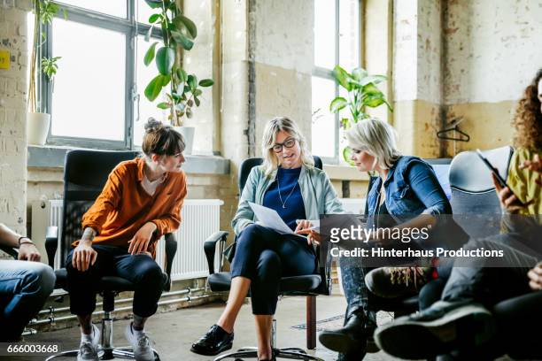 three casual businesswomen discussing during meeting - nur frauen stock-fotos und bilder