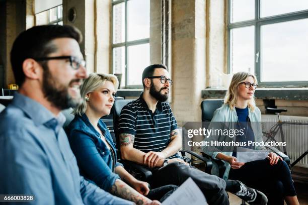 colleagues listening during a casual business meeting - apartamento tipo loft fotografías e imágenes de stock