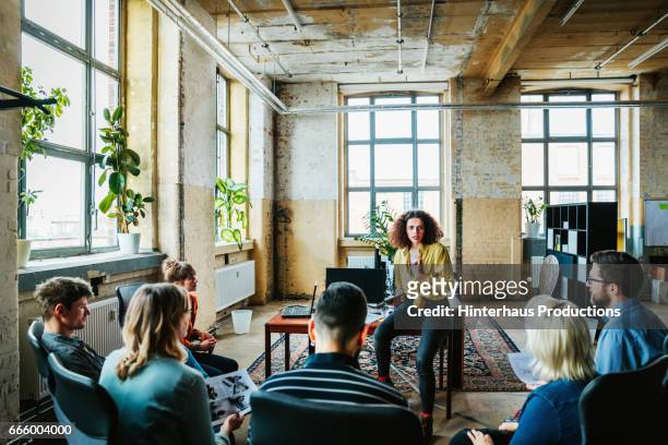 casual businesswoman leading an informal team meeting - leadership stock pictures, royalty-free photos & images