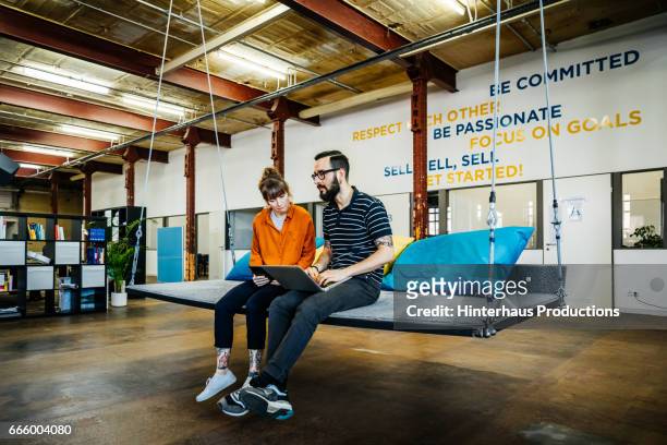 two young casual business people having an informal meeting - new business stock pictures, royalty-free photos & images