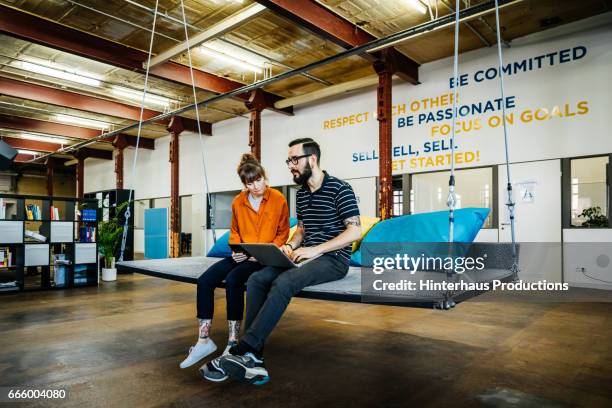 two young casual business people having an informal meeting - start up office imagens e fotografias de stock