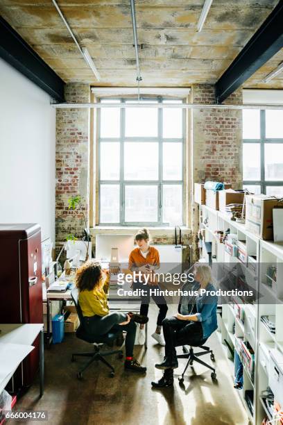 businesswomen having an informal meeting in a large office space - startup photos et images de collection