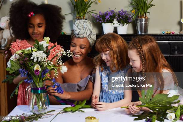 children flower arranging with their mum and friends. - eastersowhite stock-fotos und bilder