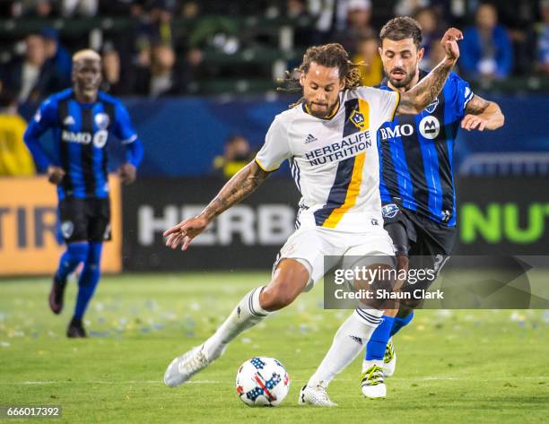 Jermaine Jones of Los Angeles Galaxy crosses the ball as Hernan Bernardello of Montreal Impact defends during Los Angeles Galaxy's MLS match against...