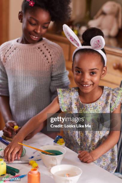 children doing easter crafts, painting easter eggs. - eastersowhite stock-fotos und bilder