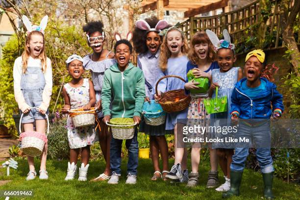 group of children having fun on an easter egg hunt. - easter garden stock-fotos und bilder