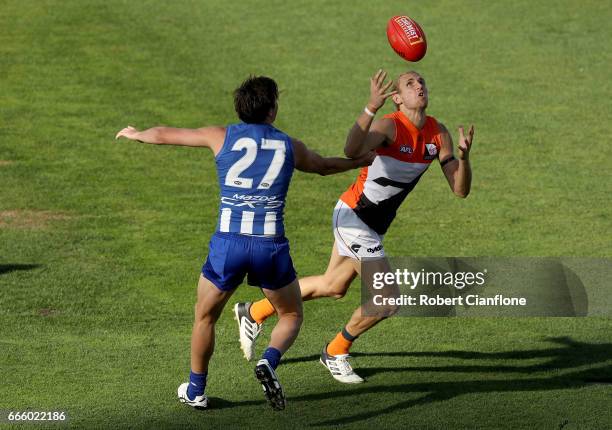 Nick Haynes of the Giants is challenged by Taylor Garner of the Kangaroos during the round three AFL match between the North Melbourne Kangaroos and...