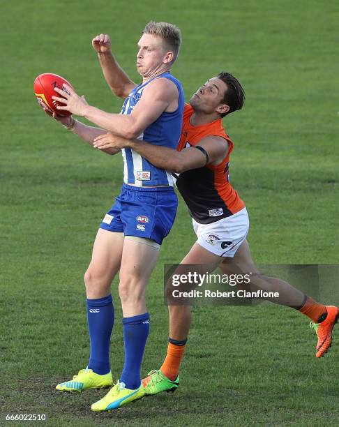 Jack Ziebell of the Kangaroos is challenged by Toby Greene of the Giants during the round three AFL match between the North Melbourne Kangaroos and...