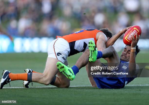 Lindsay Thomas of the Kangaroos is challenged by Heath Shaw of the Giants during the round three AFL match between the North Melbourne Kangaroos and...