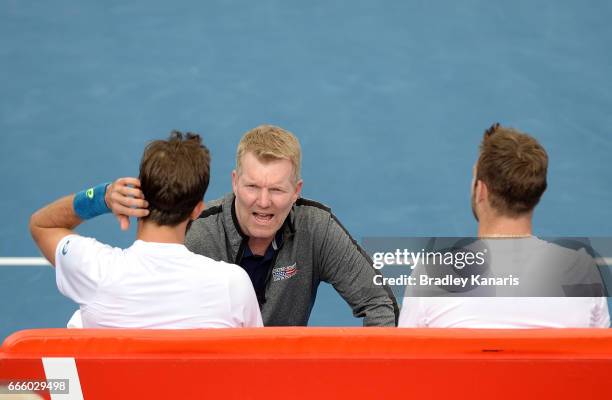 Team Captain Jim Courier of the USA talks tactics with Steve Johnson and Jack Sock of the USA in their doubles match against Sam Groth and John Peers...