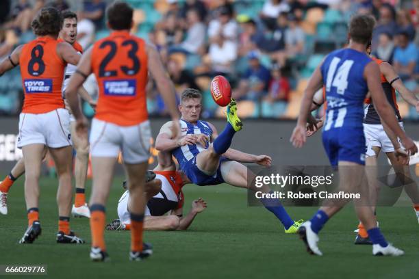 Jack Ziebell of the Kangaroos kicks the ball as he is tackled during the round three AFL match between the North Melbourne Kangaroos and the Greater...