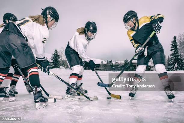 teenage girls playing ice hockey on outdoor rink in winter - hockey helmet stock pictures, royalty-free photos & images