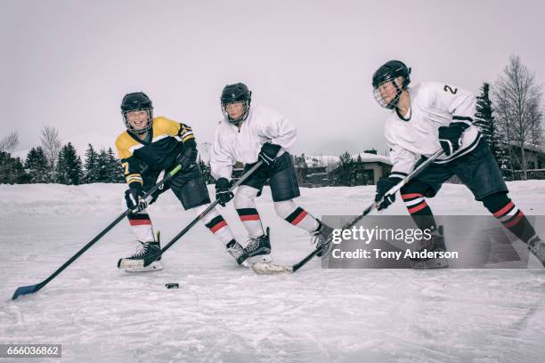 teenage girls playing ice hockey on outdoor rink in winter - girls ice hockey stock pictures, royalty-free photos & images