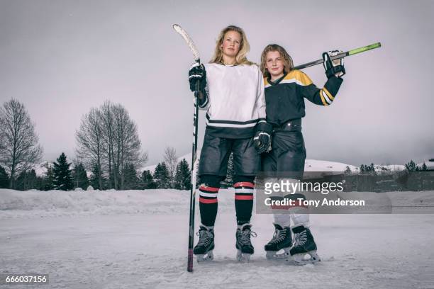 two teenage girl ice hockey players standing on rink outdoors in winter - hockey rink stock pictures, royalty-free photos & images