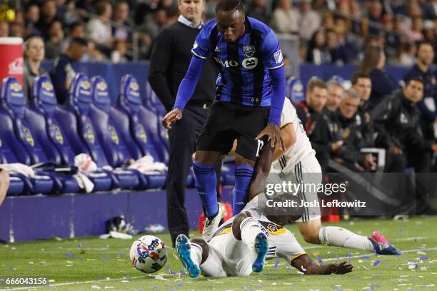 Ema Boateng slides into play against Ballou Jean-Yves Tabla of the Montreal Impact during the Los Angeles Galaxy's MLS match against the Montreal...