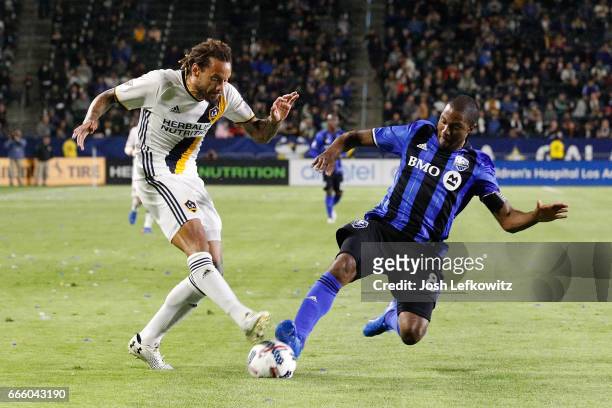 Jermaine Jones of the Los Angeles Galaxy attempts to kick the ball while Patrice Bernier of the Montreal Impact slides into play during the Los...