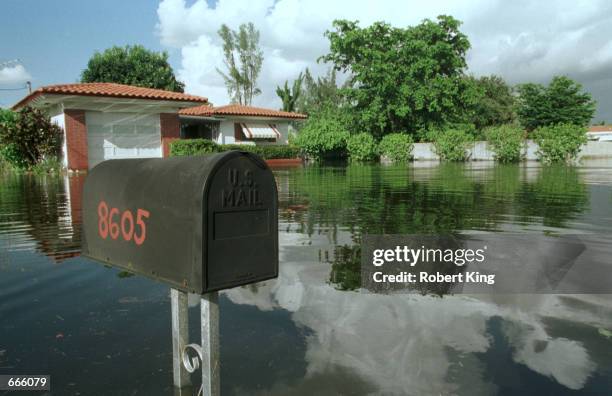 Flood waters cover a house's front yard October 5, 2000 in Miami after a tropical depression swamped the city, leaving over 6,000 homes damaged and...