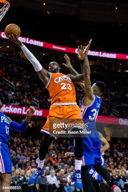 LeBron James of the Cleveland Cavaliers shoots between Gerald Henderson and Shawn Long of the Philadelphia 76ers during the second half at Quicken...