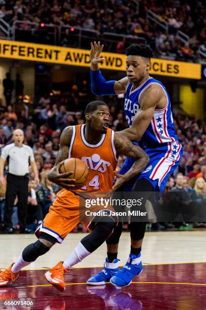 DeAndre Liggins of the Cleveland Cavaliers drives around Richaun Holmes of the Philadelphia 76ers during the second half at Quicken Loans Arena on...