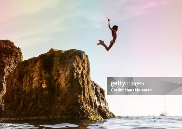 kid diving off the cliff - girl diving fotografías e imágenes de stock