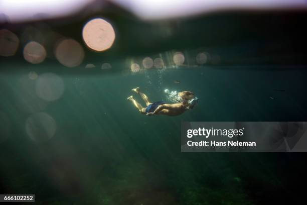 underwater view of boy diving - kid under water stock-fotos und bilder