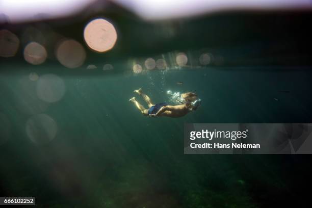 underwater view of boy diving - alleen jongens stockfoto's en -beelden