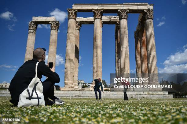 Woman watches a performance entitled ' My sweet country' by artists Prinz Gholam at the Temple of Olympian Zeus in Athens on April 8 in the frames of...