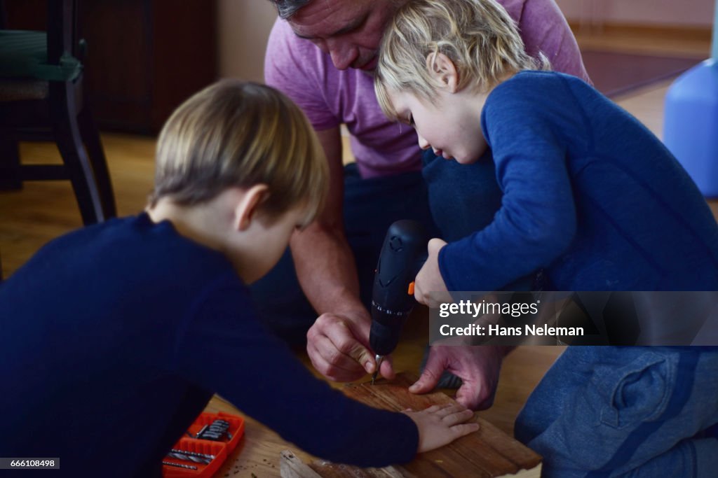 Man and kids drilling wood