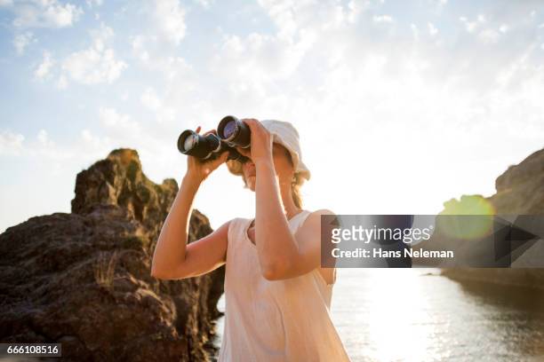 woman looking through binoculars - looking through binoculars stock pictures, royalty-free photos & images