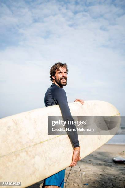 man with surfboard - kerala surf foto e immagini stock