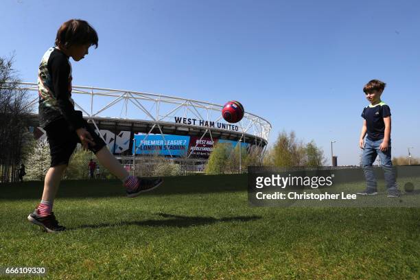 Two fans plays football outisde the stadium prior to the Premier League match between West Ham United and Swansea City at London Stadium on April 8,...