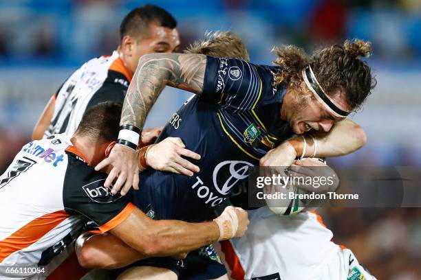 Ethan Lowe of the Cowboys is tackled by the Tigers defence during the round six NRL match between the North Queensland Cowboys and the Wests Tigers...