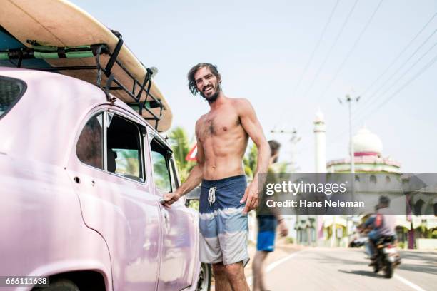 male surfer with surfboard in a car - kerala surf foto e immagini stock