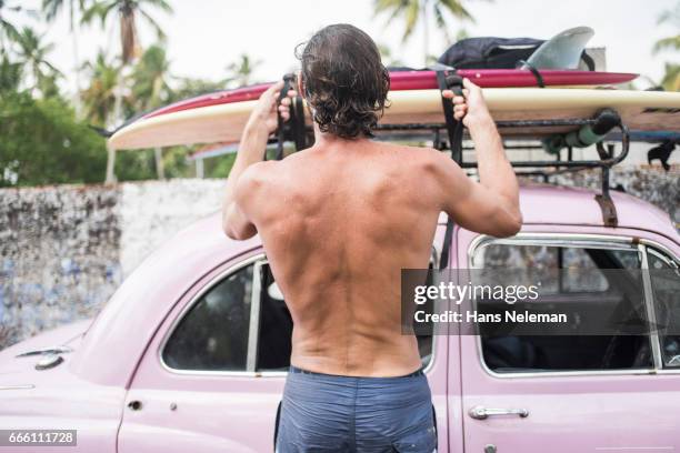 male surfer with surfboard in a car - kerala surf foto e immagini stock