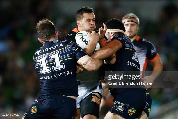 Joshua Aloiai of the Tigers is tackled by the Cowboys defence during the round six NRL match between the North Queensland Cowboys and the Wests...