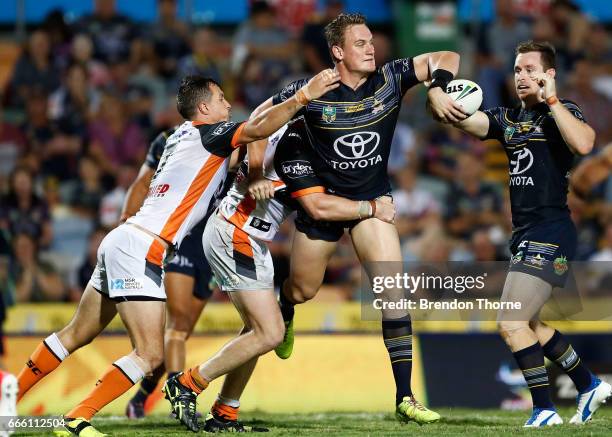 Coen Hess of the Cowboys offloads to a team mate during the round six NRL match between the North Queensland Cowboys and the Wests Tigers at...