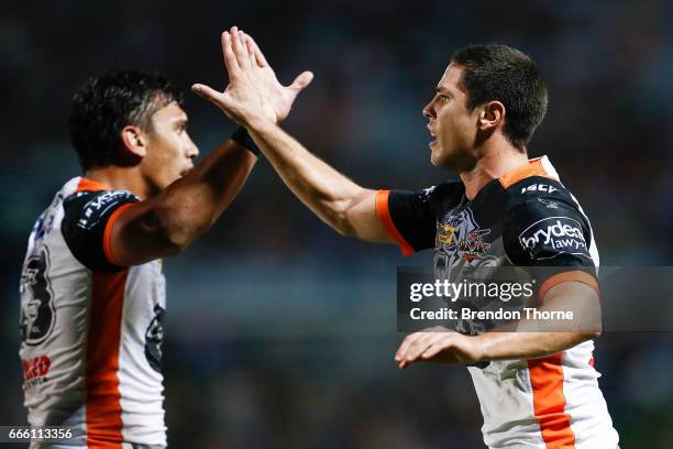 Mitchell Moses and Elijah Taylor of the Tigers celebrate during the round six NRL match between the North Queensland Cowboys and the Wests Tigers at...