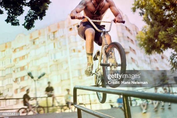 bmx rider performing bicycle stunt - low section stockfoto's en -beelden