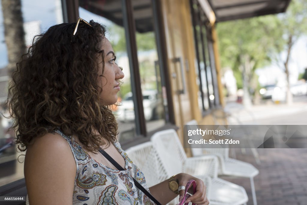 Close-up of woman sitting outside neighborhood cafe