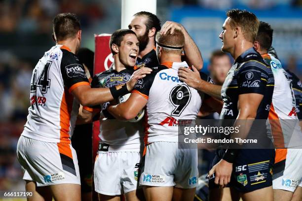 Matt McIlwrick of the Tigers celebrates with team mate Mitchell Moses after scoring a try during the round six NRL match between the North Queensland...