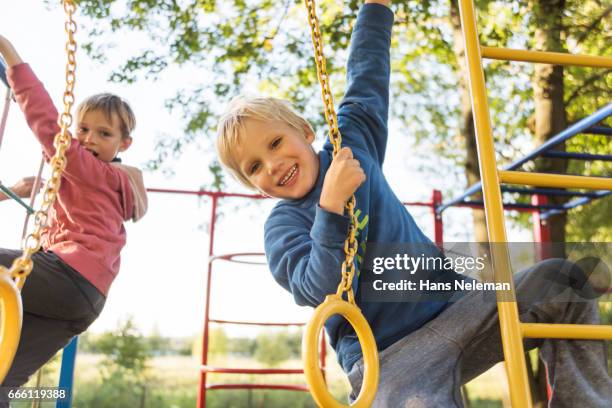 boys playing on monkey bars at playground - jungle gym stock pictures, royalty-free photos & images