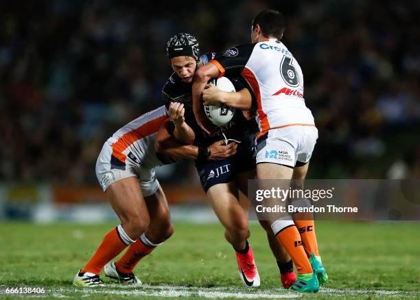 Kalyn Ponga of the Cowboys is tackled by the Tigers defence during the round six NRL match between the North Queensland Cowboys and the Wests Tigers...