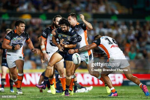 Javid Bowen of the Cowboys is tackled by the Tigers defence during the round six NRL match between the North Queensland Cowboys and the Wests Tigers...