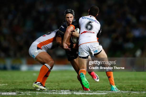 Kalyn Ponga of the Cowboys is tackled by the Tigers defence during the round six NRL match between the North Queensland Cowboys and the Wests Tigers...