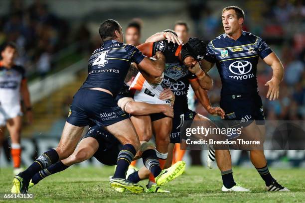 David Nofoaluma of the Tigers is tackled by the Cowboys defence during the round six NRL match between the North Queensland Cowboys and the Wests...