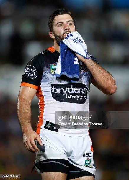 James Tedesco of the Tigers wipes his face with a cloth during the round six NRL match between the North Queensland Cowboys and the Wests Tigers at...